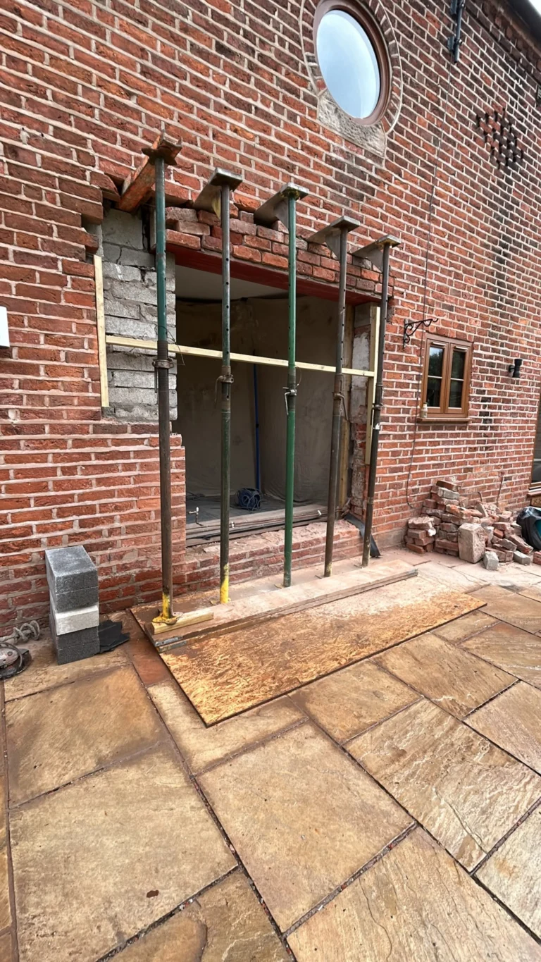 Temporary supports beneath a brick wall during structural work